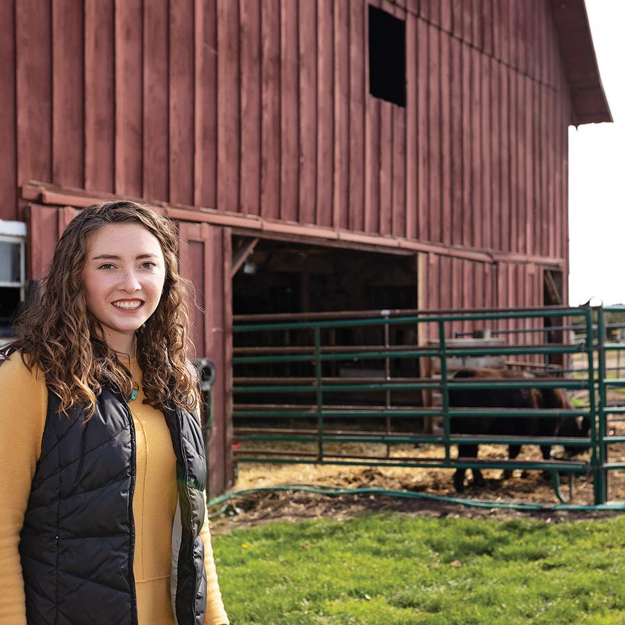 Madalyn Neuschwander standing near a barn